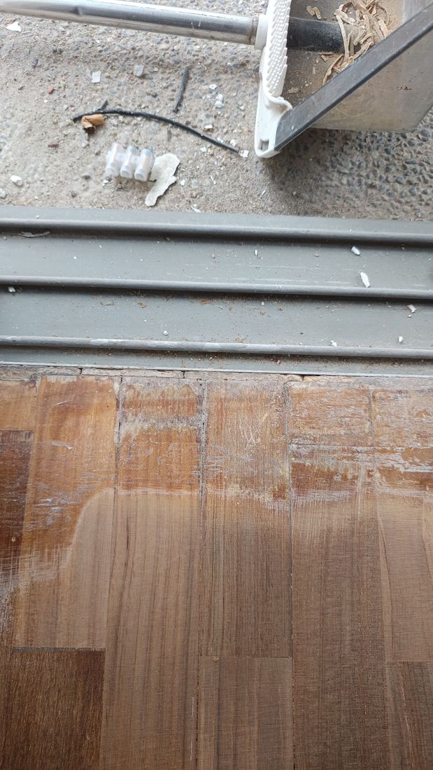 Sanded parquet next to a sliding door track