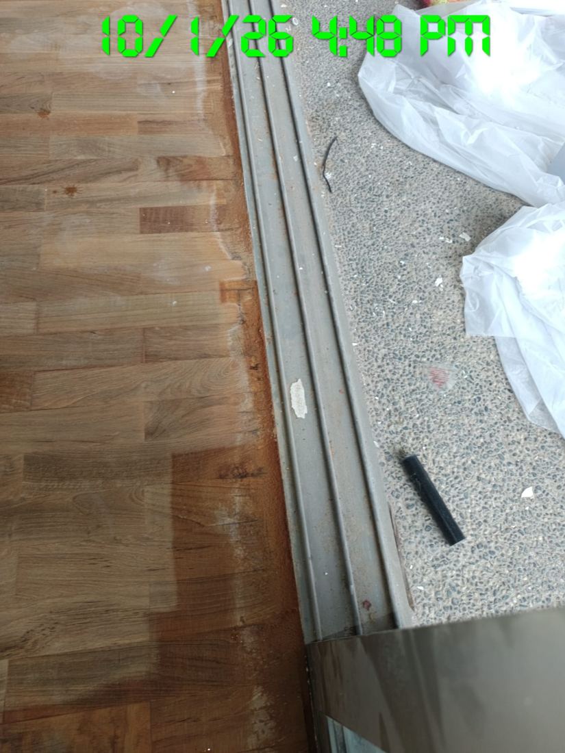 Parquet edge strip beside a door track during sanding