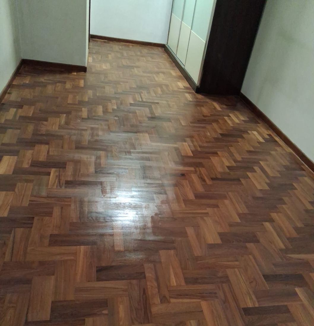 Glossy teak herringbone parquet in a bedroom